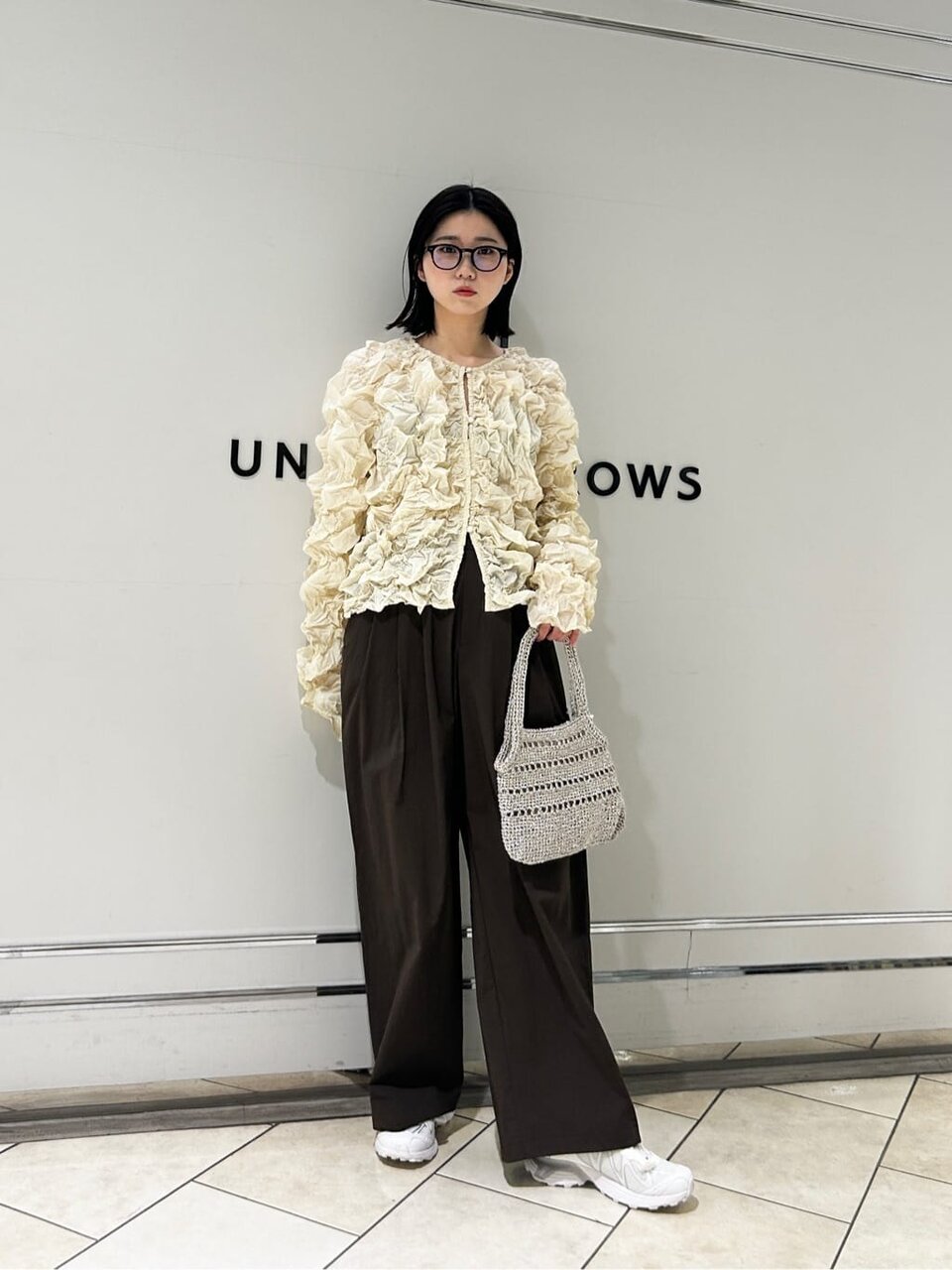 シャーリングブルゾンとスニーカーの女性