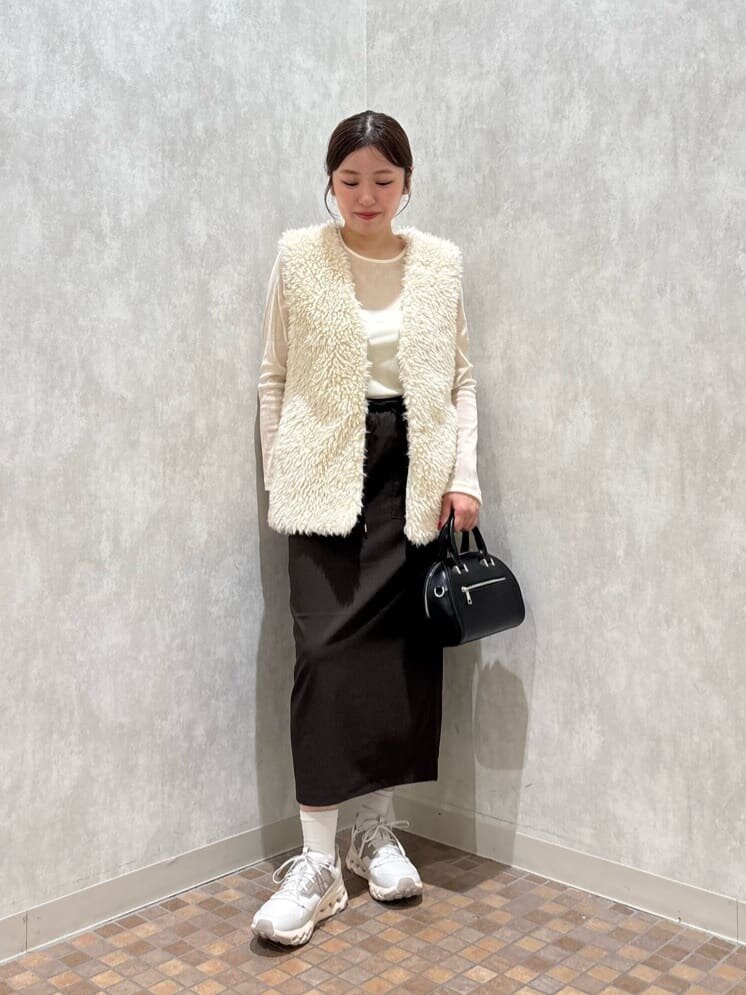 ボアベストとタイトスカートを着た女性