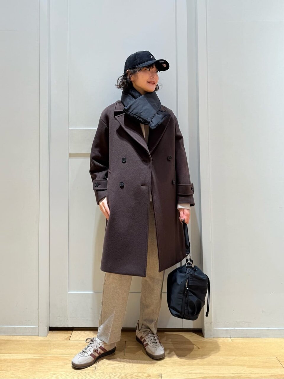 チェスターコートとスニーカーの女性