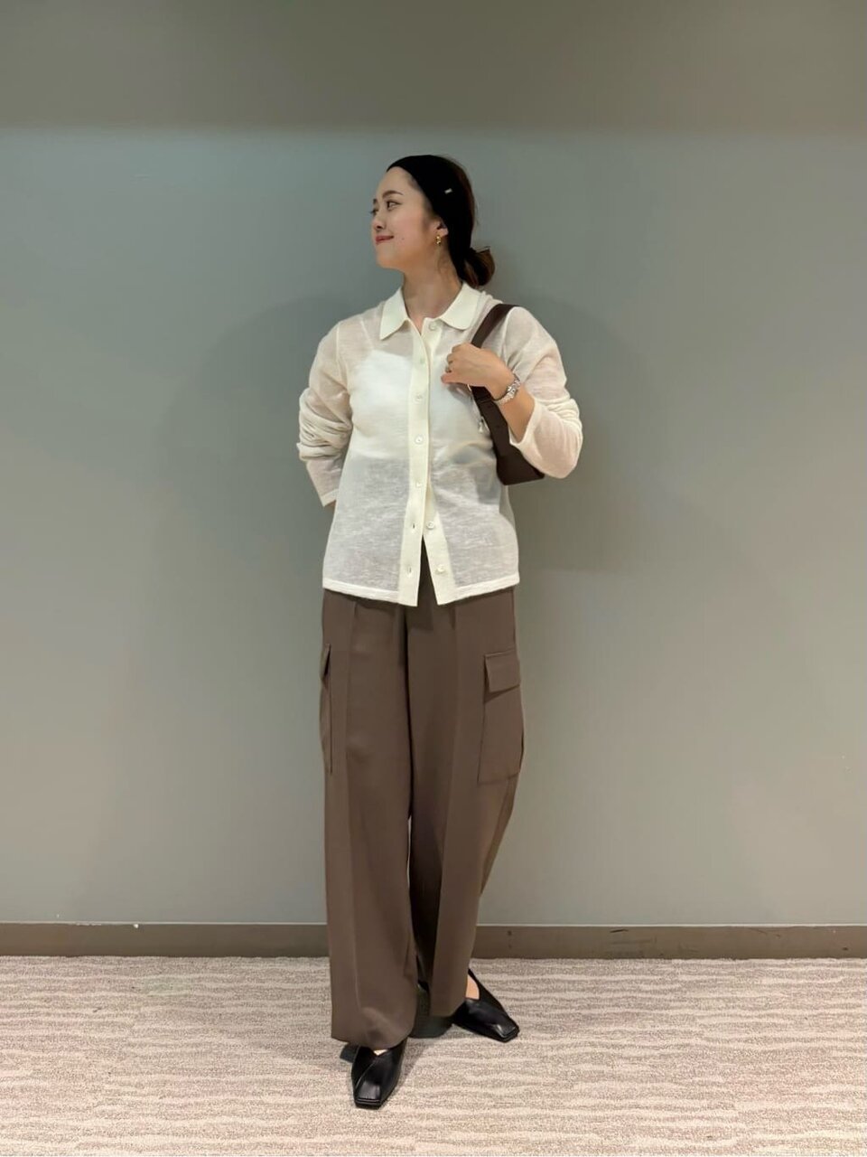 ニットカーディガンとカーゴパンツを着た女性