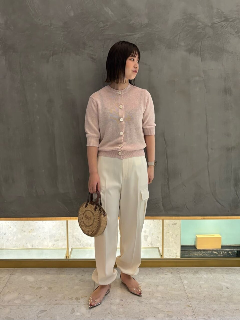 ニットカーディガンとカーゴパンツを着た女性