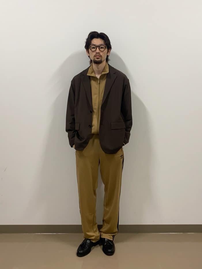 ジャケットとトラックパンツを着た男性