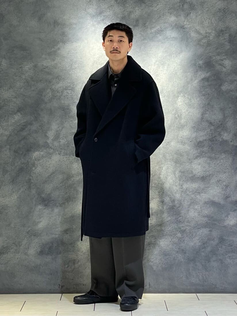 ラップコートとワイドパンツを着た男性