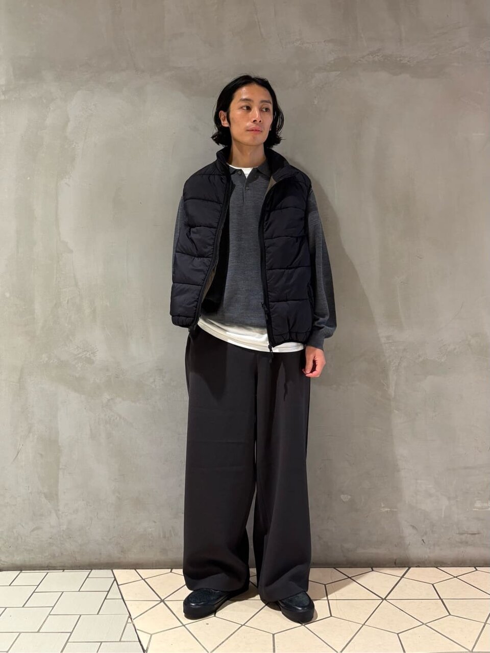 ダウンジャケットとワイドパンツを着た男性