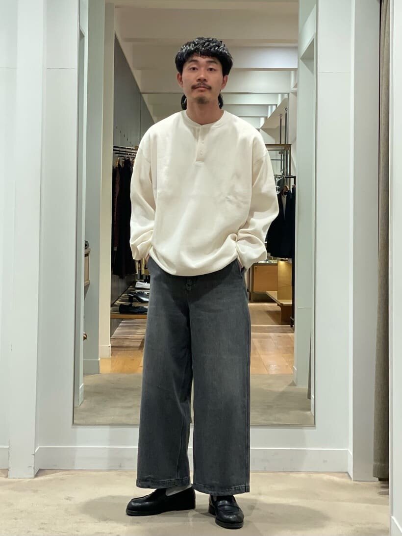 ヘンリーネックとワイドパンツを着た男性