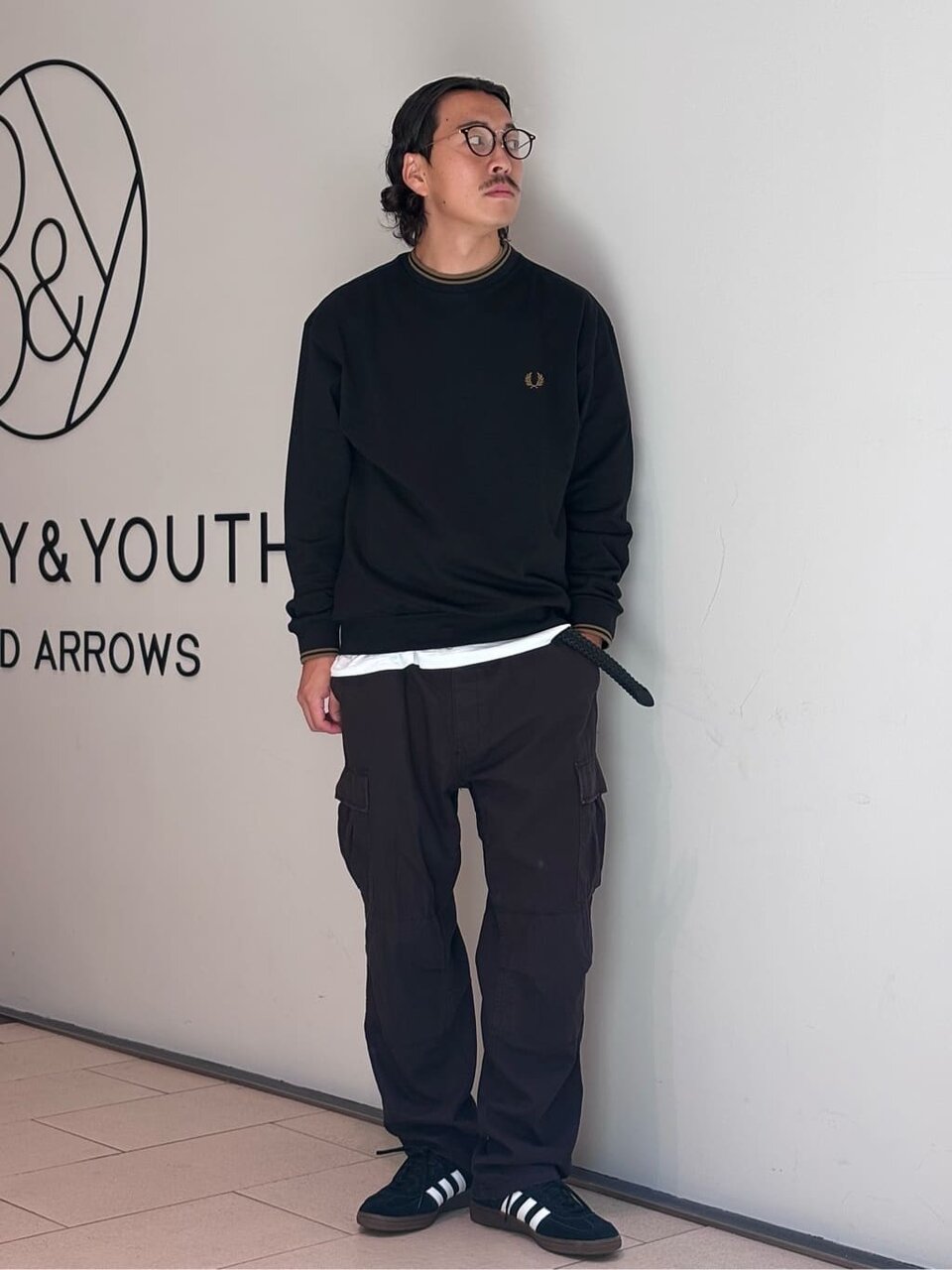 黒のスウェットとカーゴパンツを着た男性