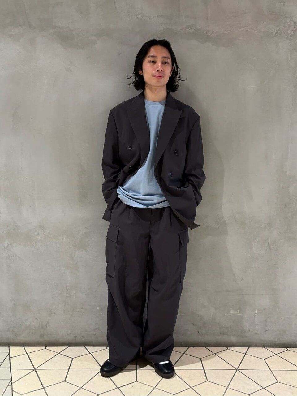 テーラードジャケットとカーゴパンツを着た男性