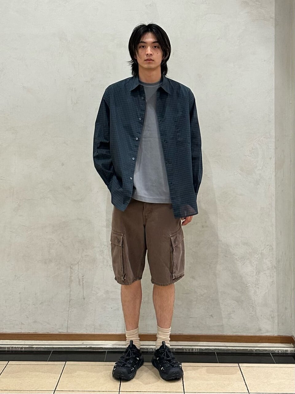 チェックシャツとカーゴパンツを着た男性