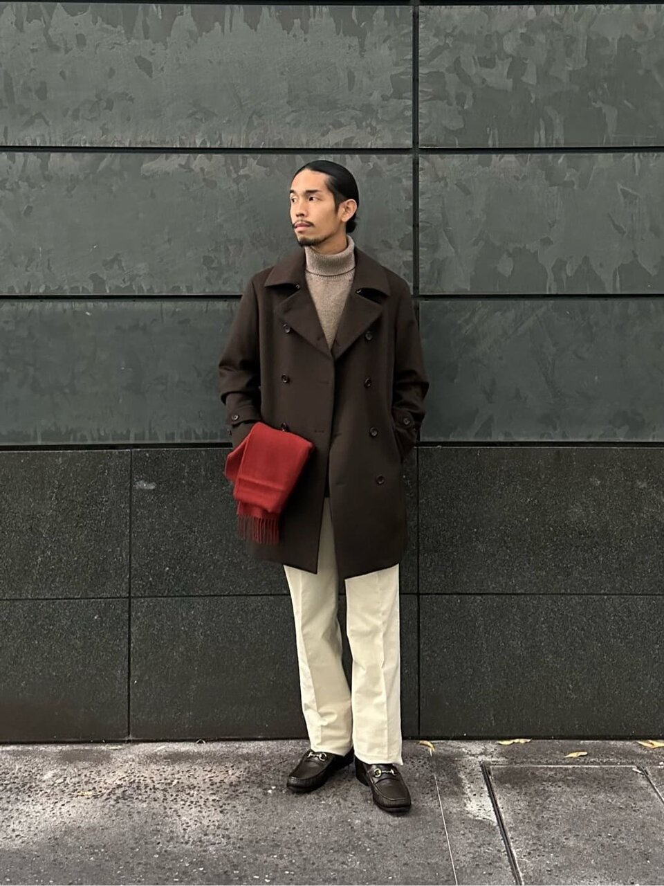 タートルネックニットにトレンチコートをあわせた男性