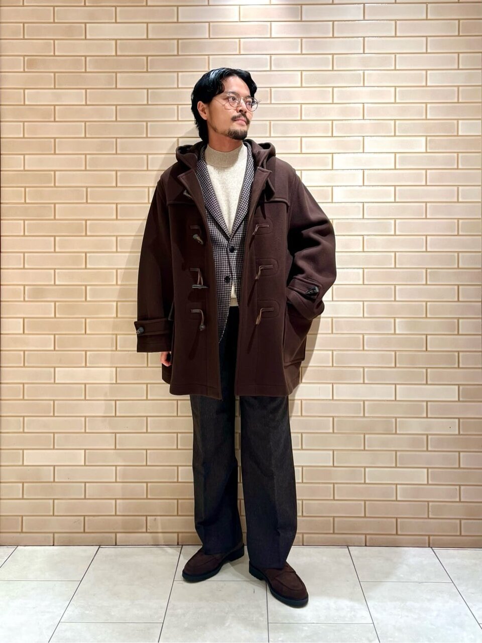 セットアップスーツにダッフルコートをあわせた男性