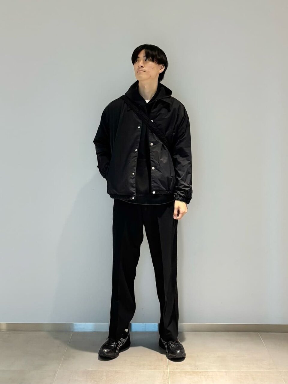 パーカーにコーチジャケットをあわせた男性