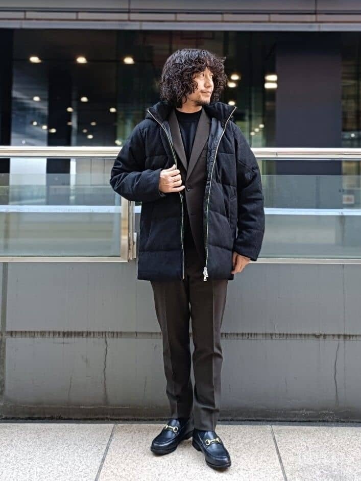 スーツにダウンジャケットを着た男性