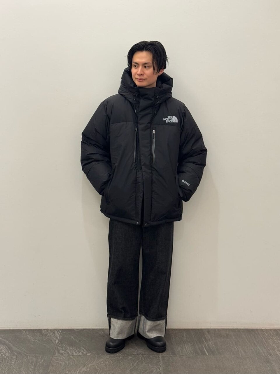 ダウンジャケットにデニムをあわせた男性