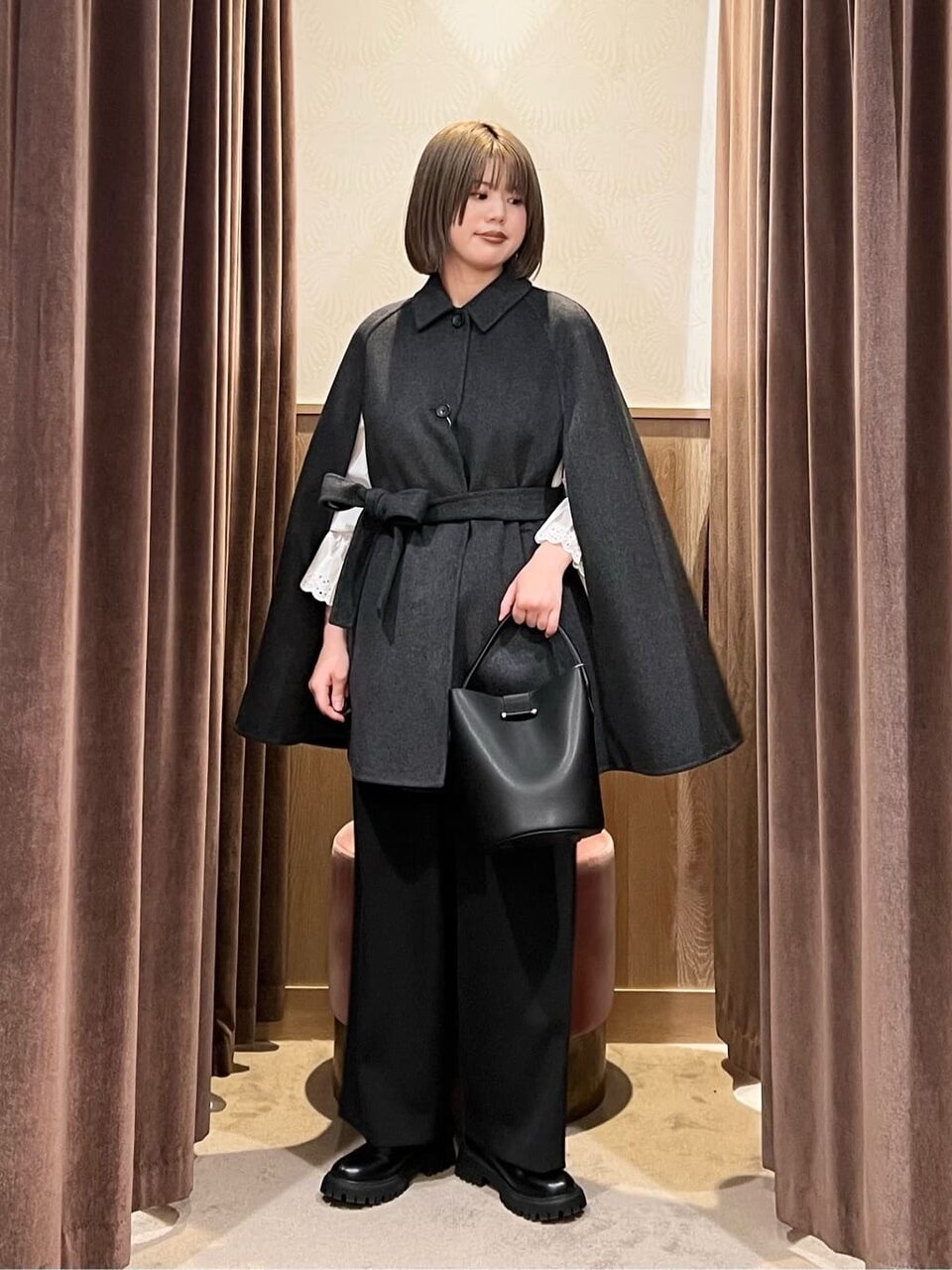 ケープコートとチノパンコーデの女性