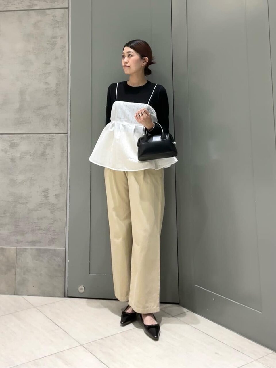 ジャガードキャミソールとチノパンコーデの女性