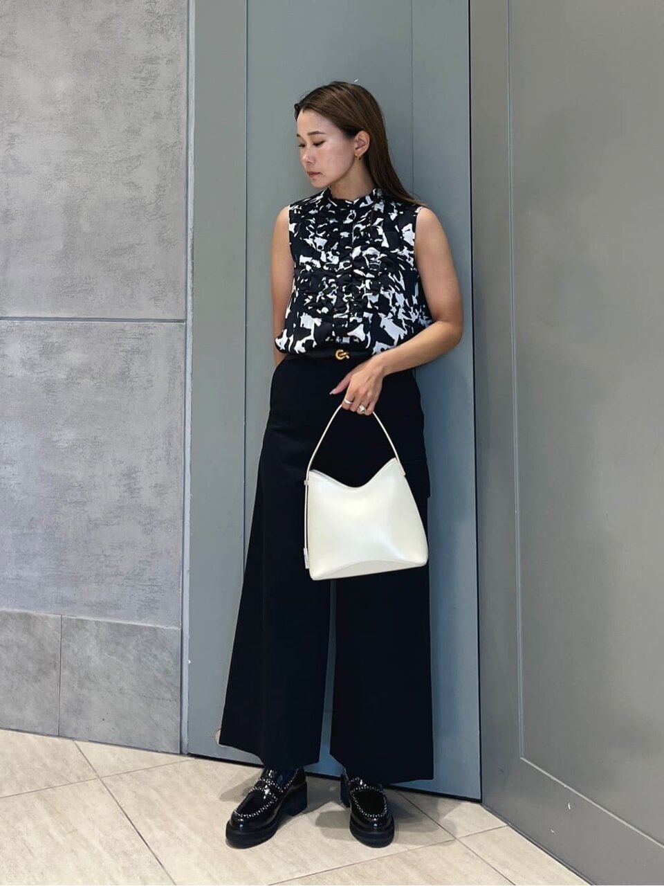 フリルブラウスとチノパンコーデの女性