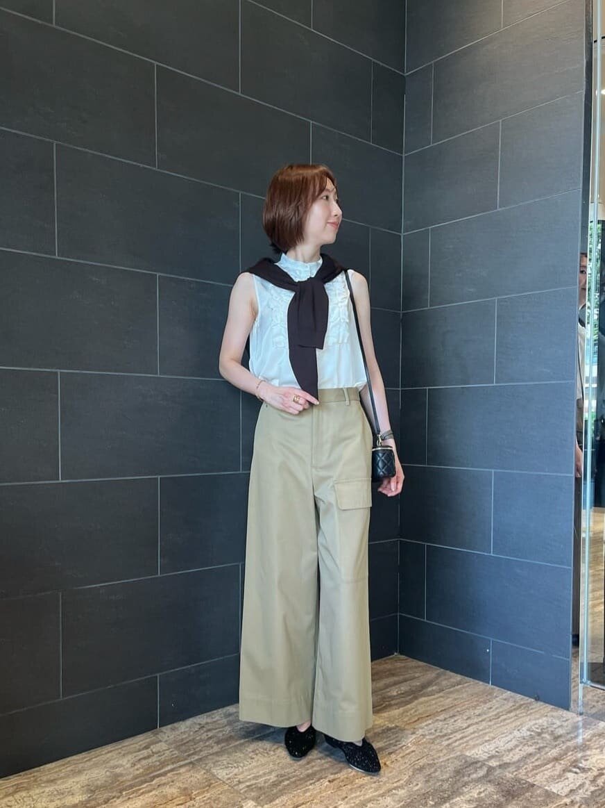 カーディガンを羽織ったチノパンコーデの女性