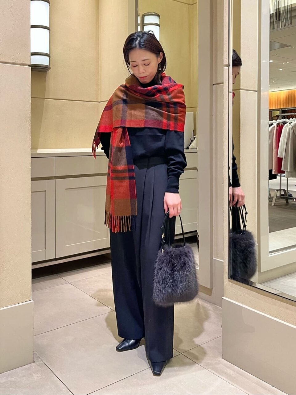 タートルニットとチノパンコーデの女性