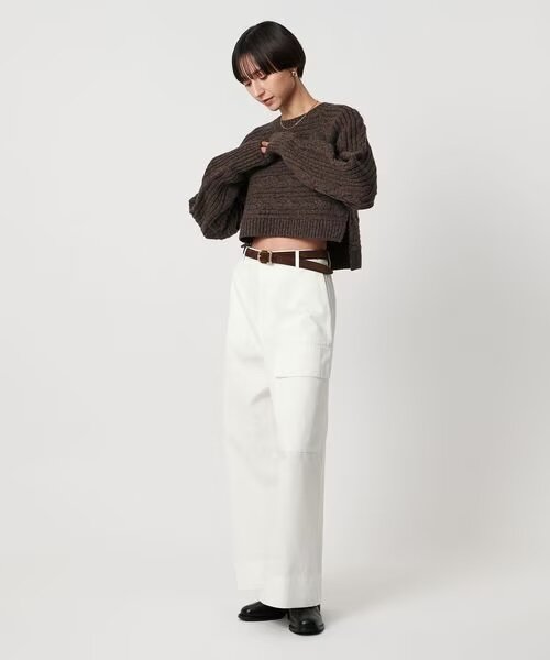 ニットとチノパンコーデの女性