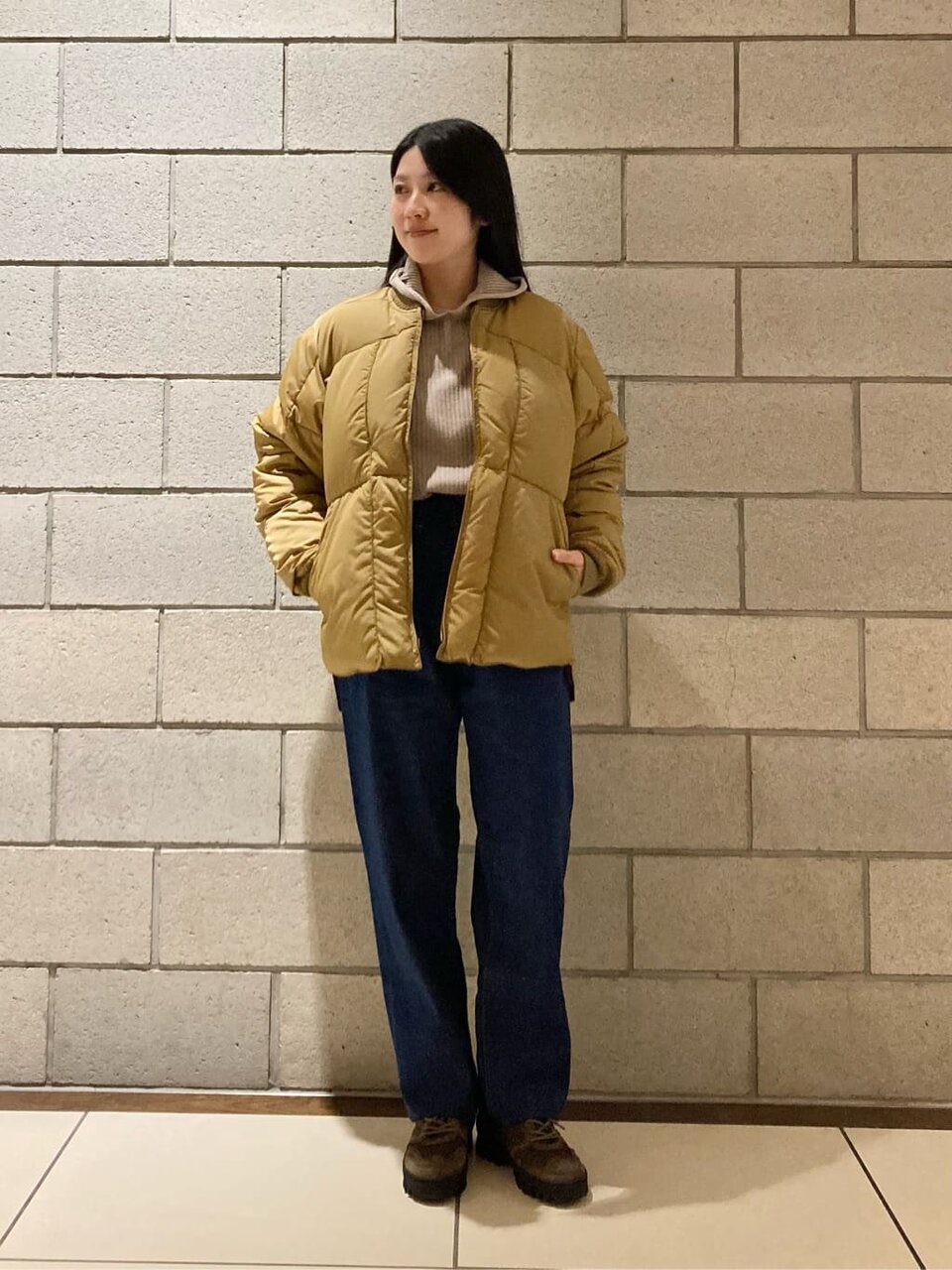 デニムパンツにダウンジャケットをあわせた女性