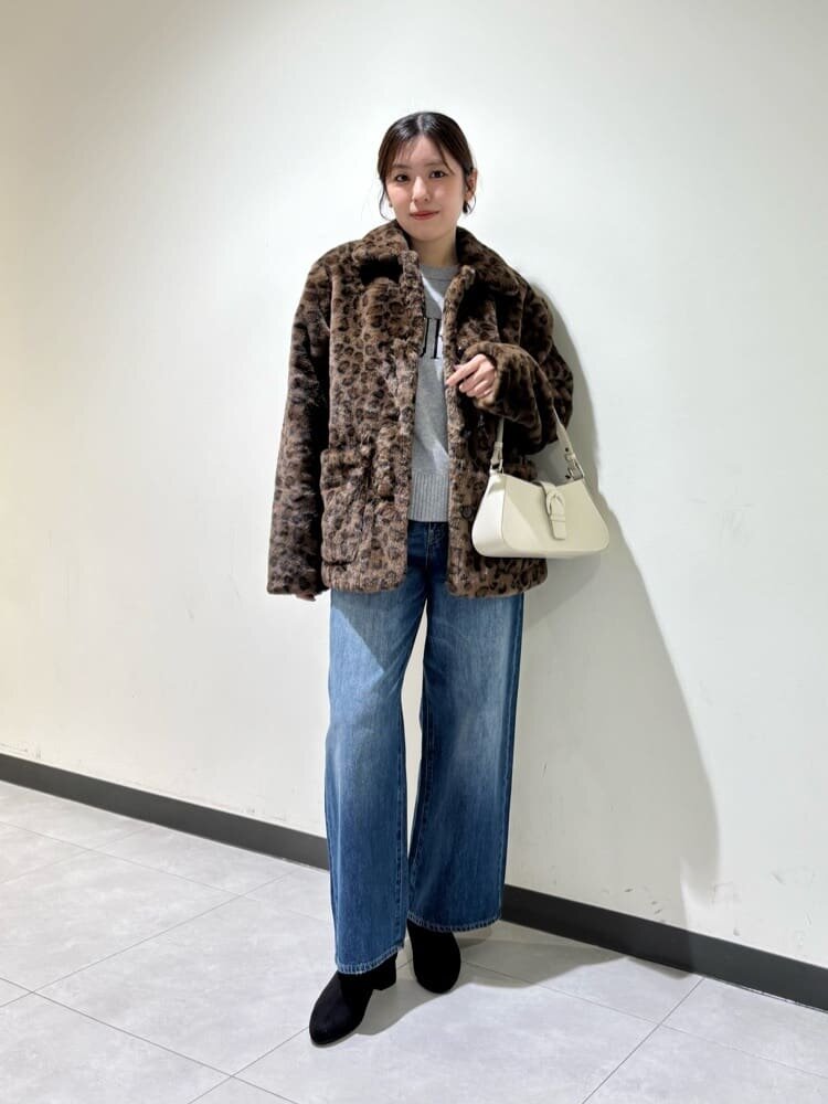 デニムパンツにショートブーツをあわせた女性