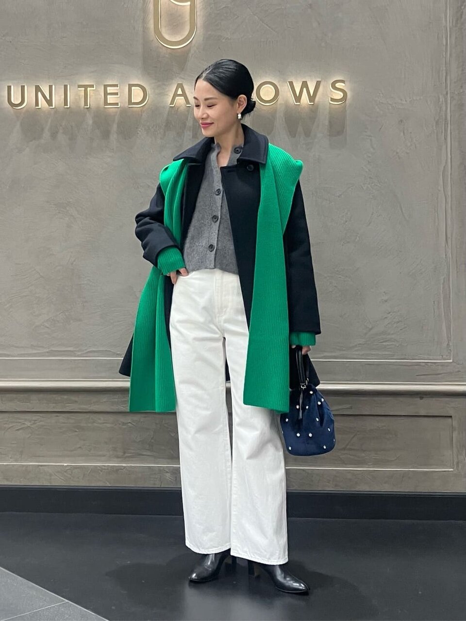 デニムパンツにミドルコートをあわせた女性