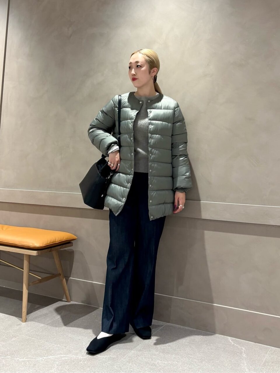 ダウンジャケットにフレアデニムをあわせた女性