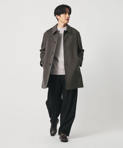 ウール素材のコートとレザーシューズを着こなす男性