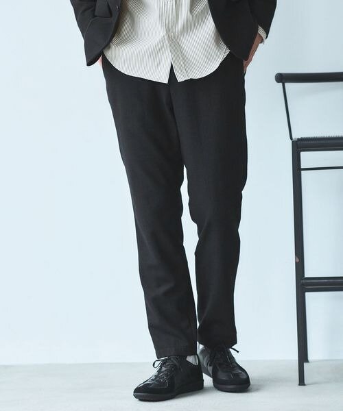 テーパードパンツをはいた男性