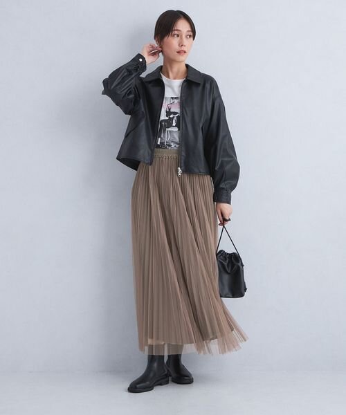 ピンクのプリーツスカートを穿いた女性