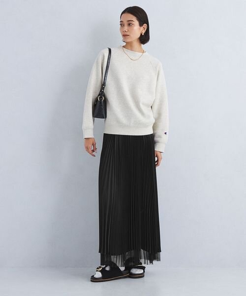 スウェットにプリーツスカートを着た女性