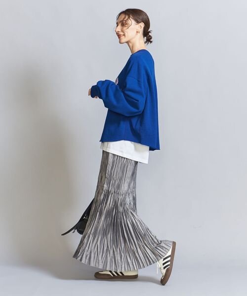 プリーツスカートにスニーカーをあわせた女性