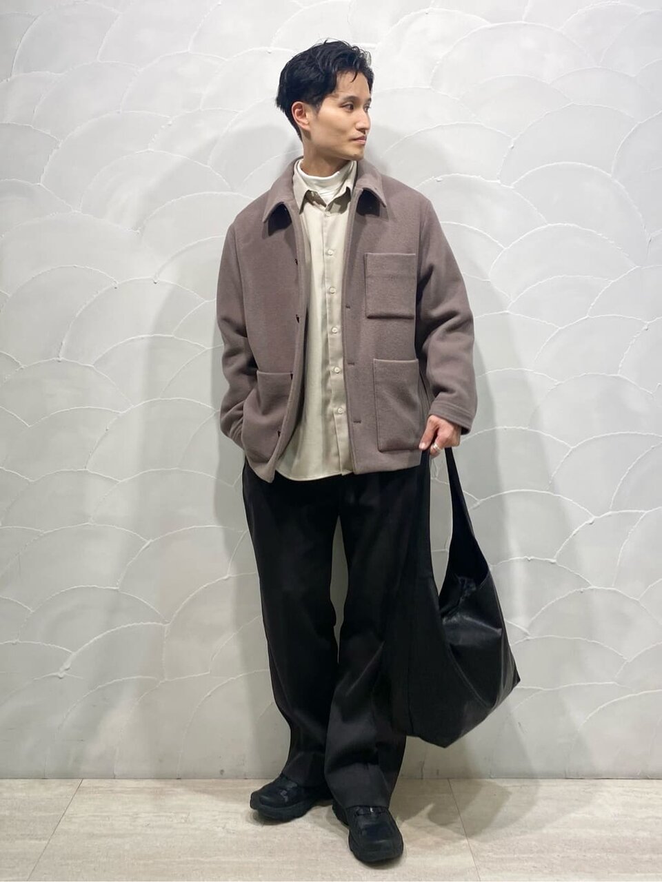 ステンカラーコートとスラックスを着た男性