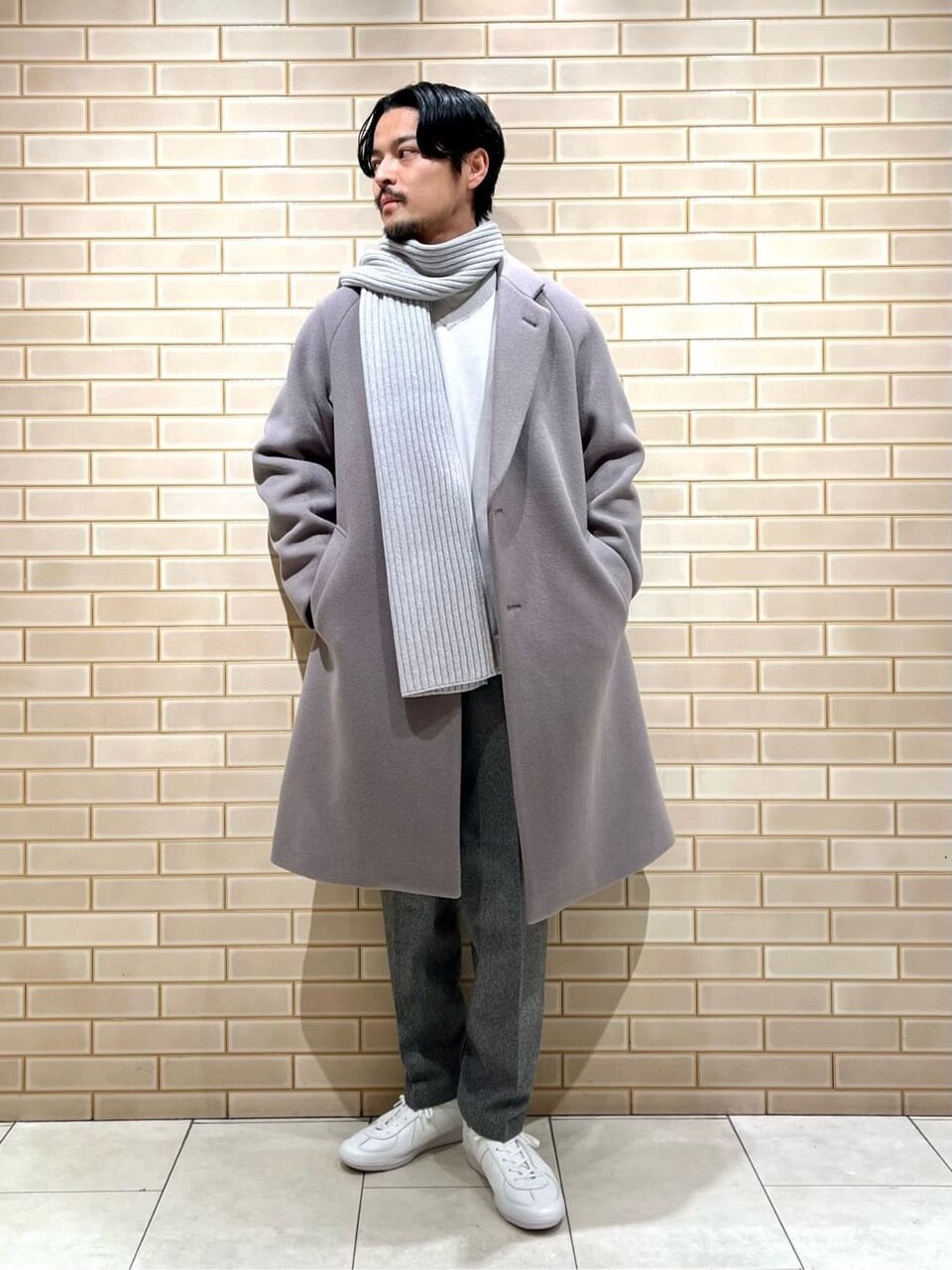ステンカラーコートとスラックスを着た男性