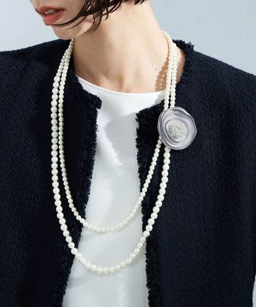 コサージュ付きネックレスを着けた女性