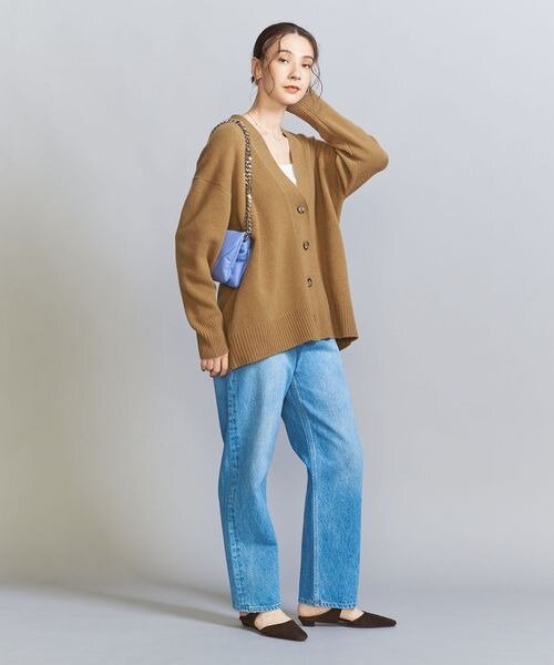 ベージュのカーディガンとデニムコーデの女性
