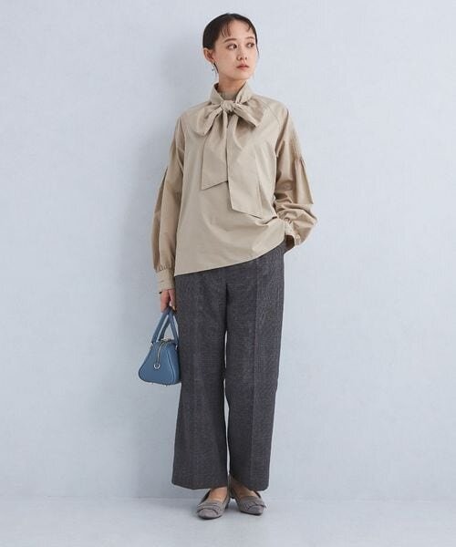 ベージュのボウタイブラウスを着た女性