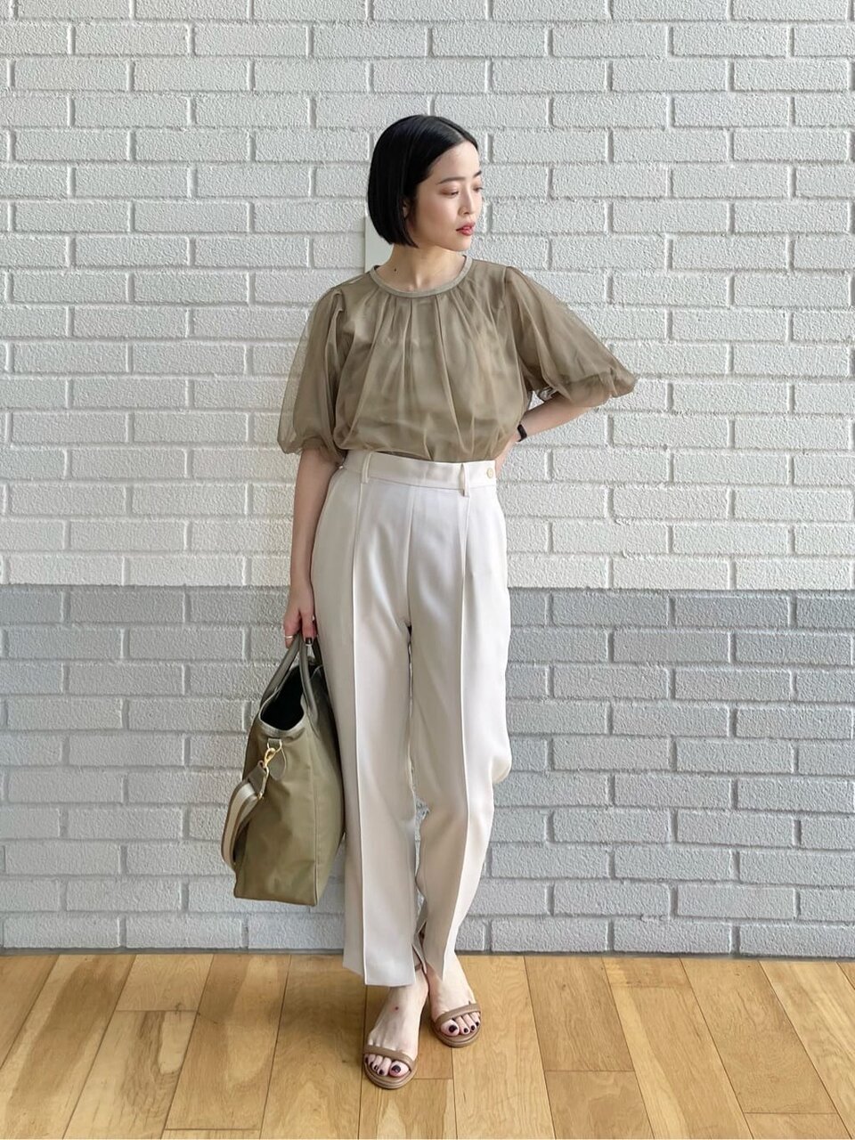 ベージュのプルオーバーを着用している女性