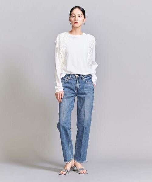 デニムパンツにサンダルをあわせた女性