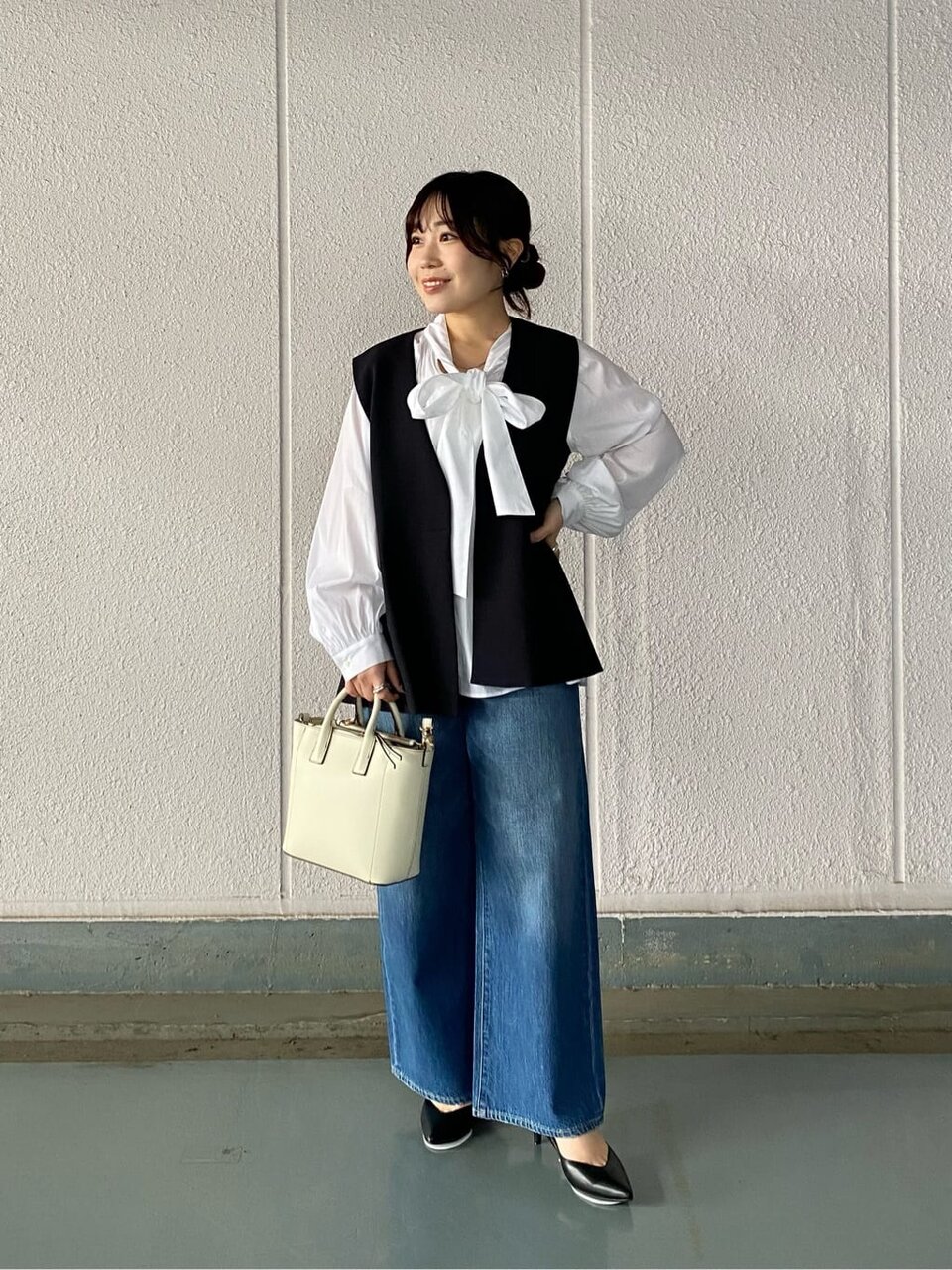 ジレとブラウスをあわせた女性