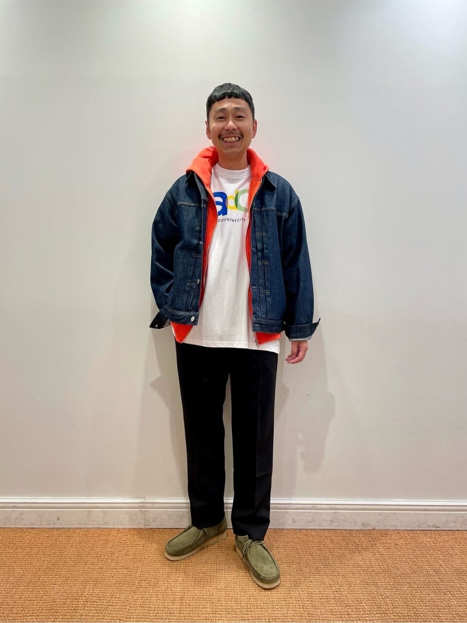 オレンジが目を引くレイヤードコーデ