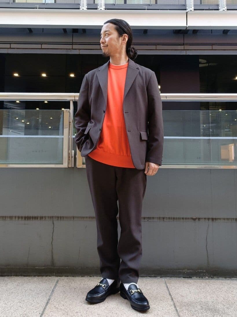 オレンジのニット×ダークグレーのセットアップのコーデ