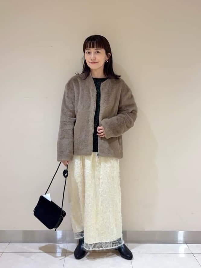 フェイクファーのノーカラーコートを着た女性