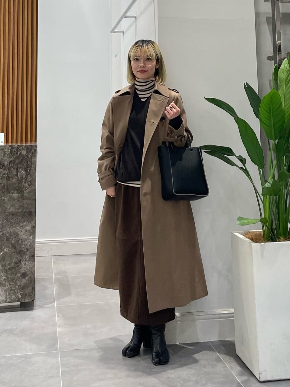 トレンチコートにスカートをあわせた女性