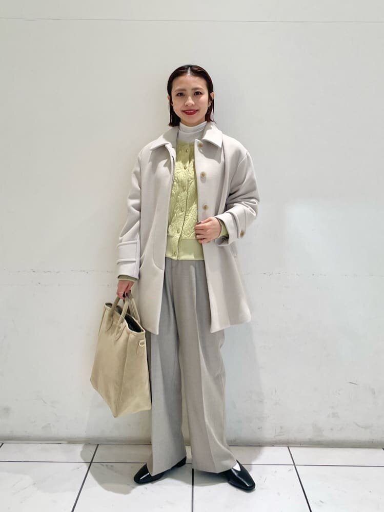 コートの下にカーディガンを着た女性