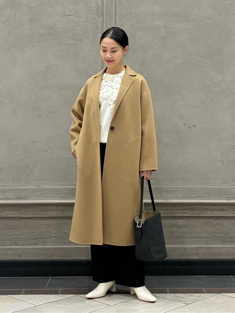 白のニットとベージュのコートのコーデ