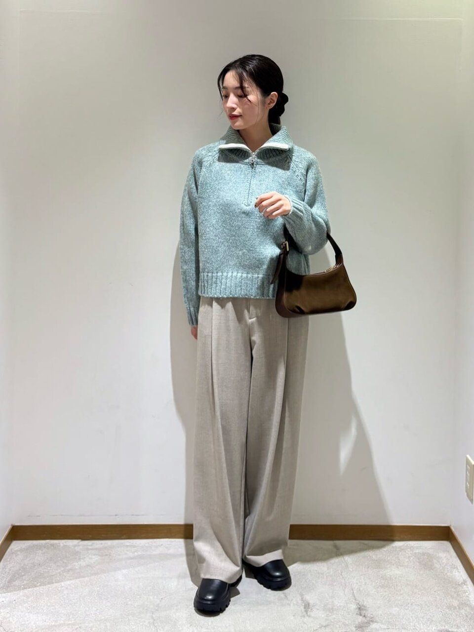 グリーンのニットとベージュのパンツのコーデ