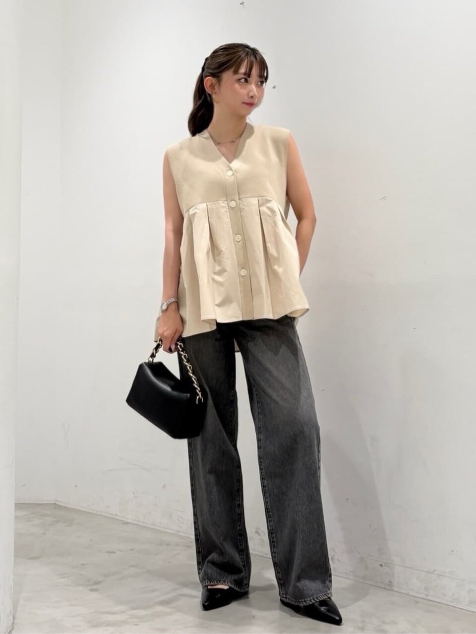 ベージュのジレと黒のデニムパンツの夏コーデ
