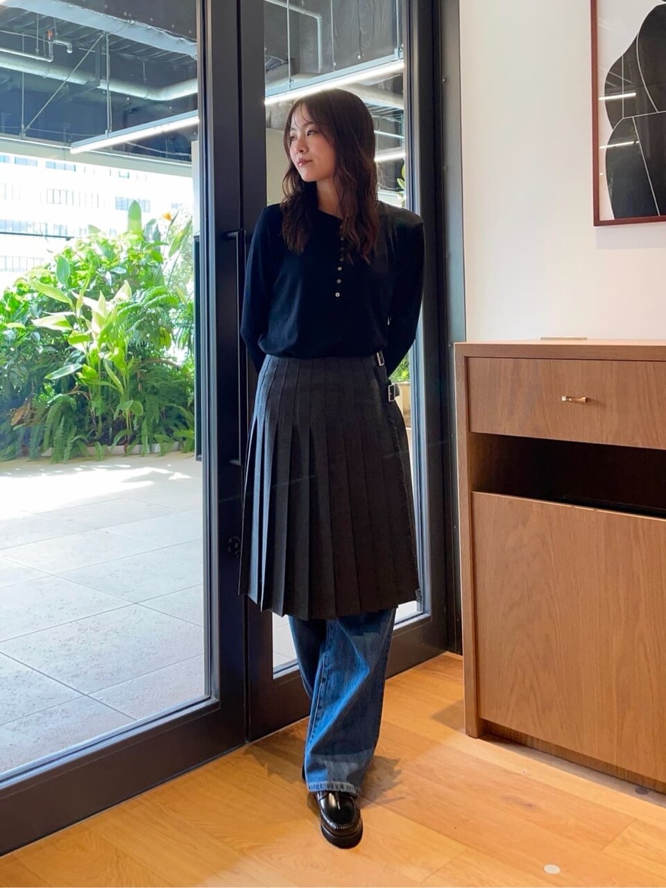 プルオーバーとプリーツスカートを着た女性