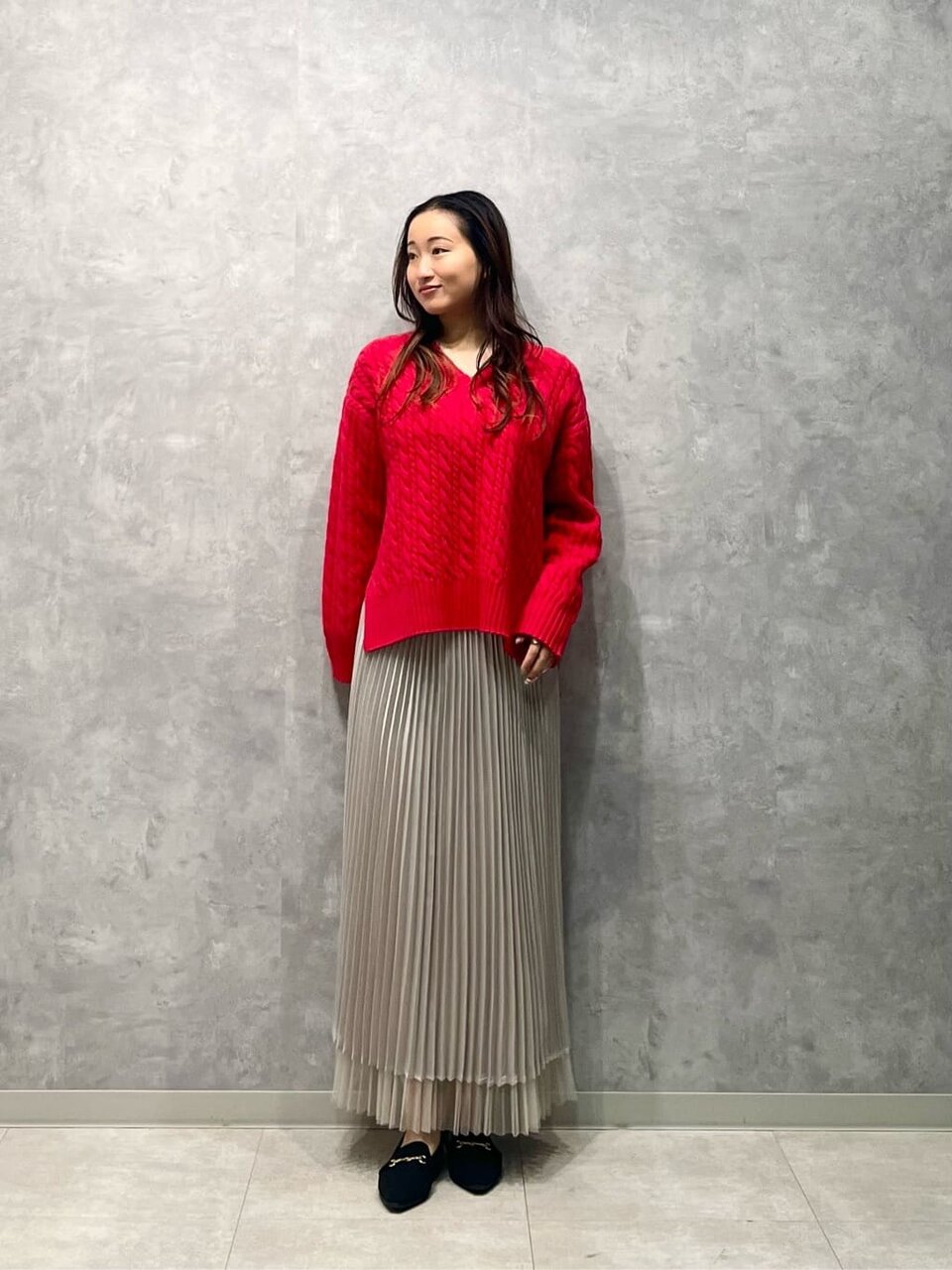 ニットとプリーツスカートを着た女性